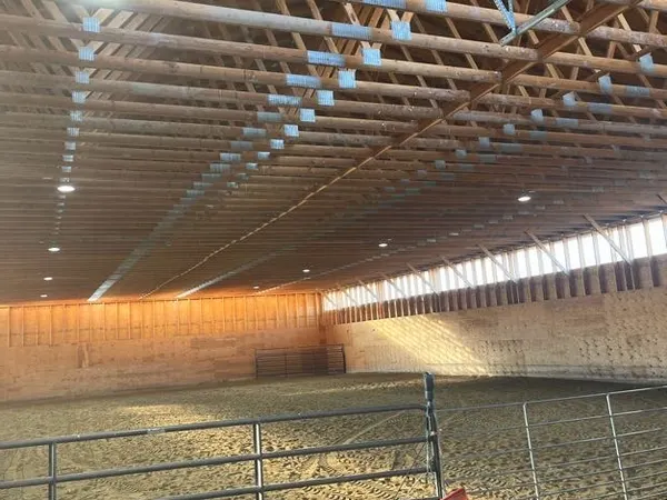 Rows of high-bay LED fixtures lighting a large timber-trussed commercial building.