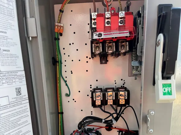 An open commercial motor-starter control panel with a Siemens combination starter, fused disconnect, and HAND-OFF-AUTO controls.
