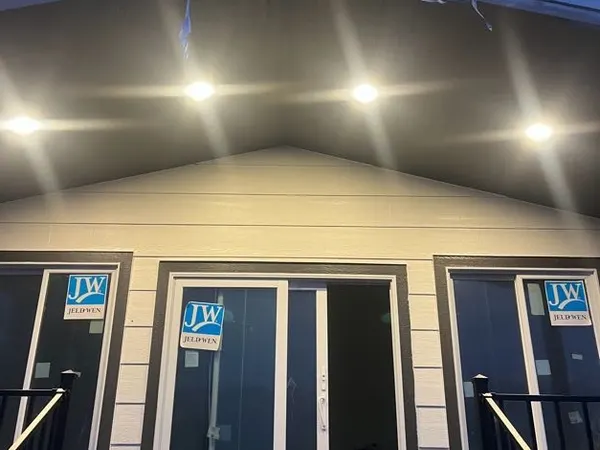 A new home's front gable with five recessed soffit lights lit at dusk.