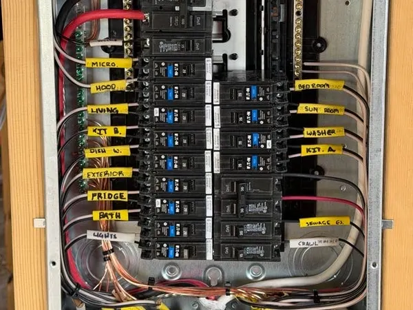 A residential breaker panel with every circuit hand-labeled and conductors combed in neatly.
