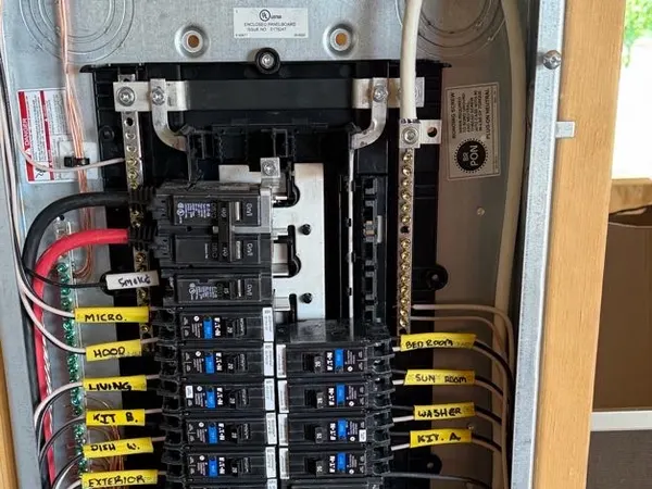 An open residential loadcenter with tidy wiring and hand-labeled breakers.