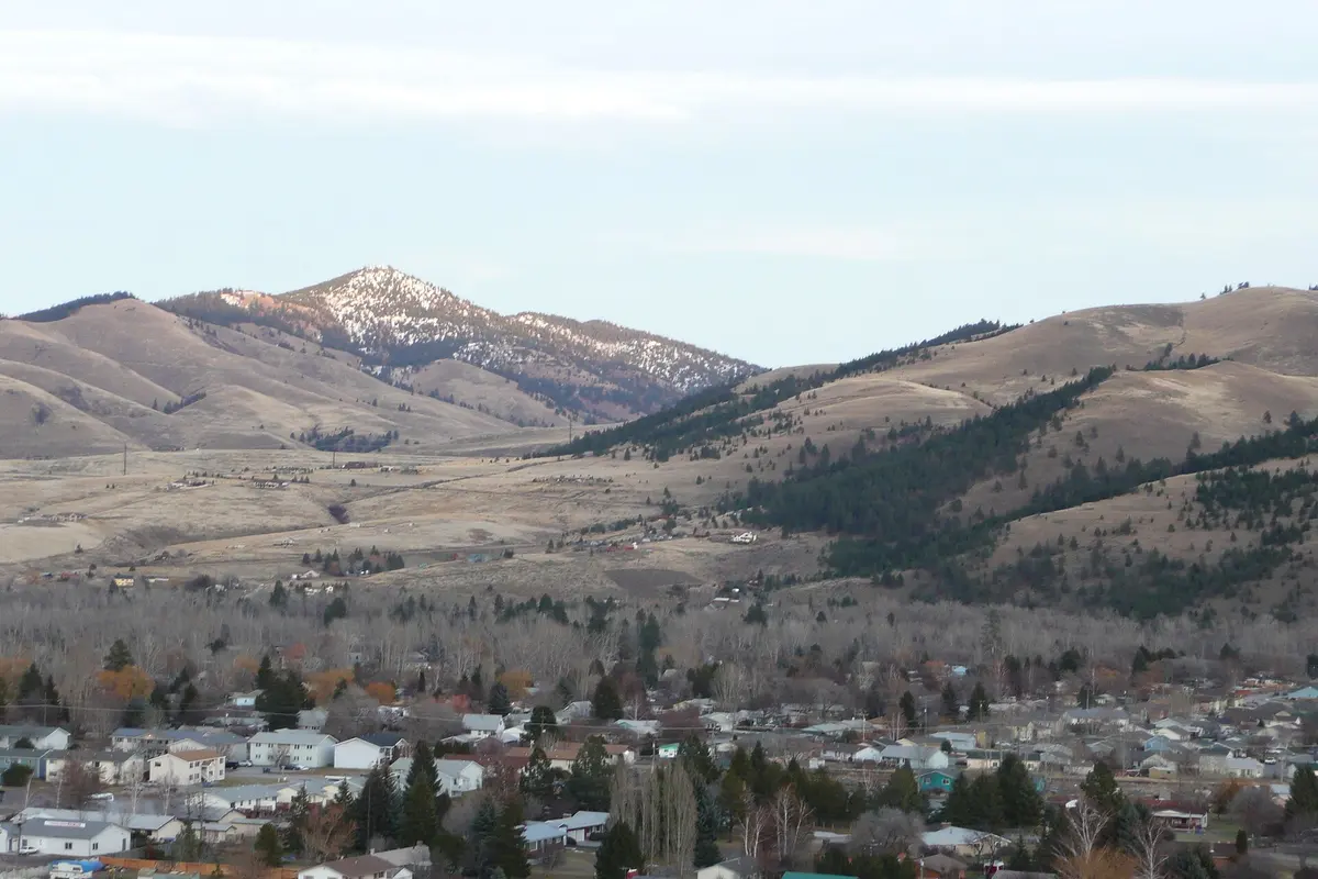 The town of Lolo, Montana spread along the valley floor with the dry foothills of the Bitterroot range rising behind it.